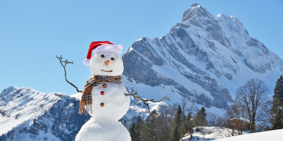 Snowman in front of alps