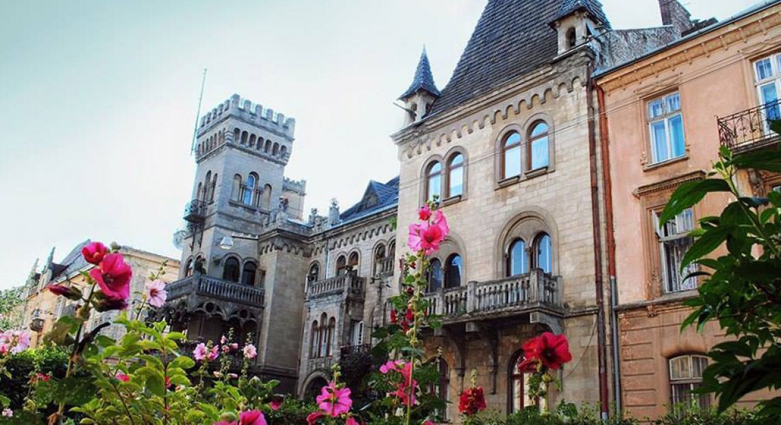 beautiful old houses with towers and garden with rose flowers