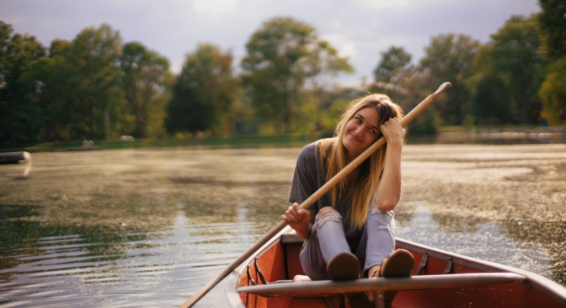 girl in boat with paddles on lake