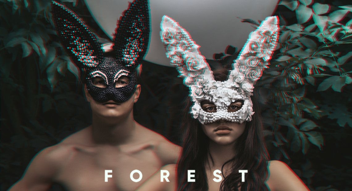 A couple wearing masks in a forest