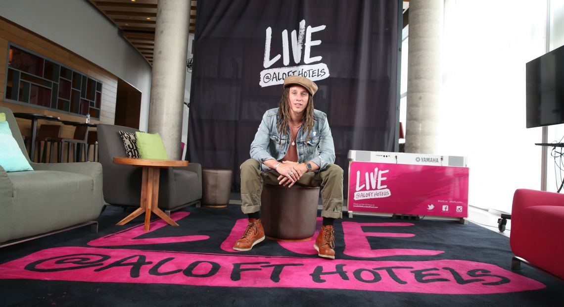 Young man sitting on an armchair in Aloft Hotel