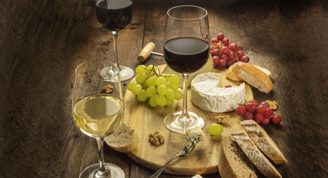 three glasses of wine, bread, cheese, nuts and grapes