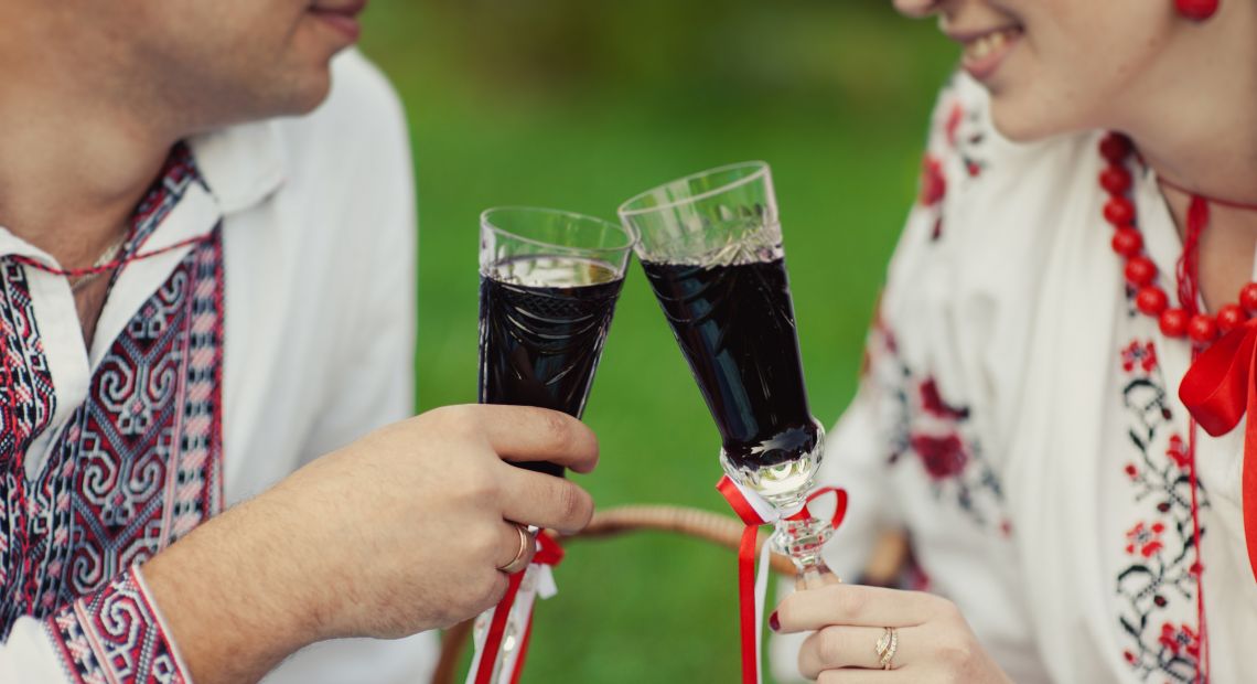 Couple sharing a glass of nalyvka on a picnic