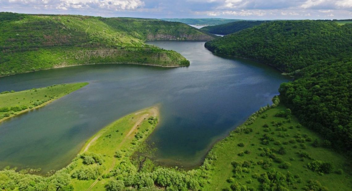 river surrounded by green hills