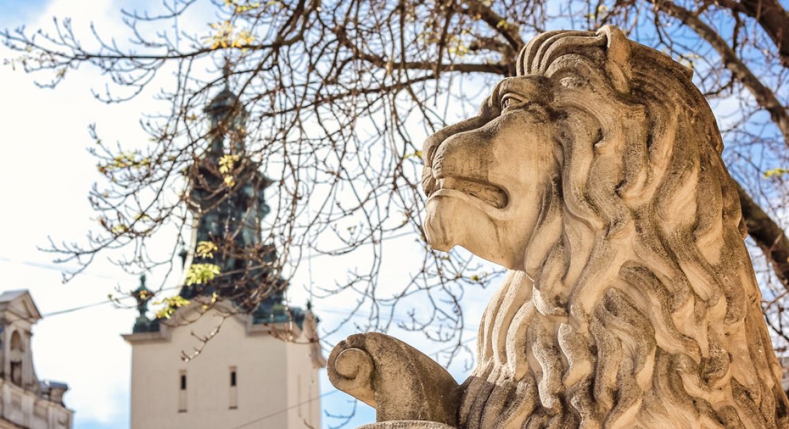 Lion statue and a church on the background in Lviv