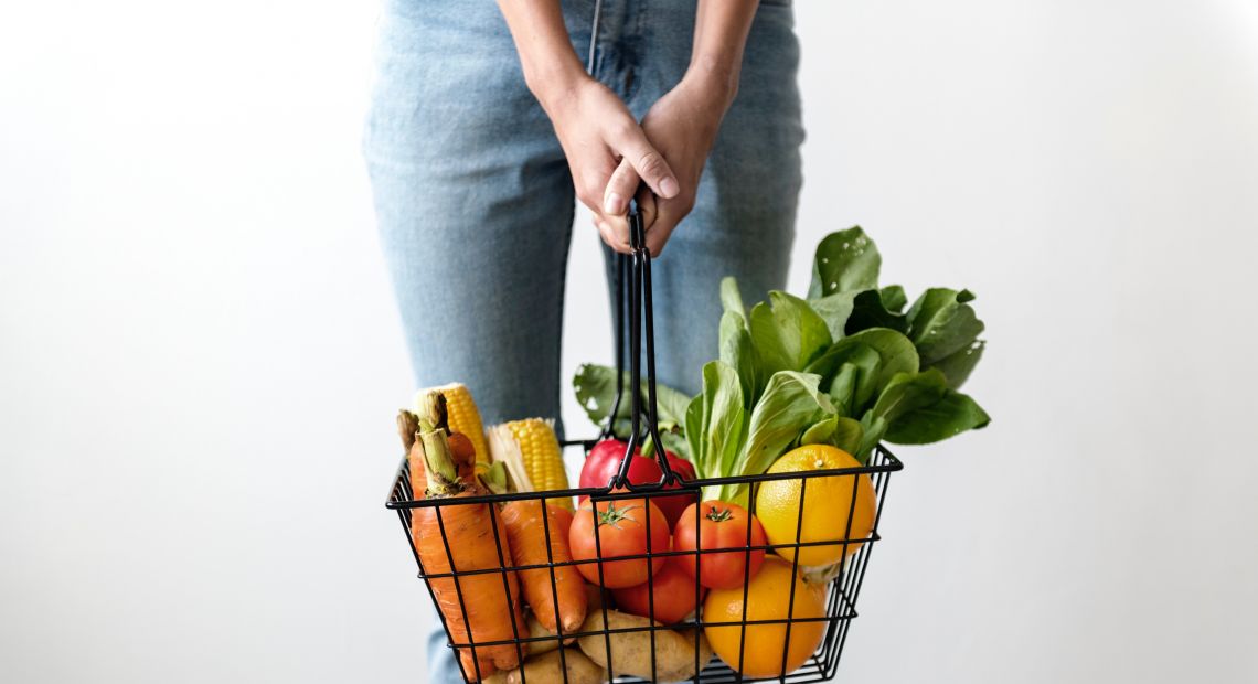 Woman holding a basket with vegetables