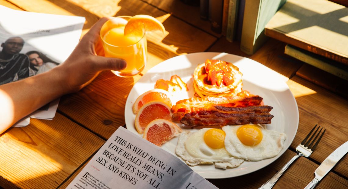 Person having eggs and juice for breakfast