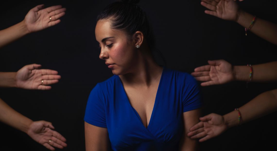 woman surrounded bu human hands