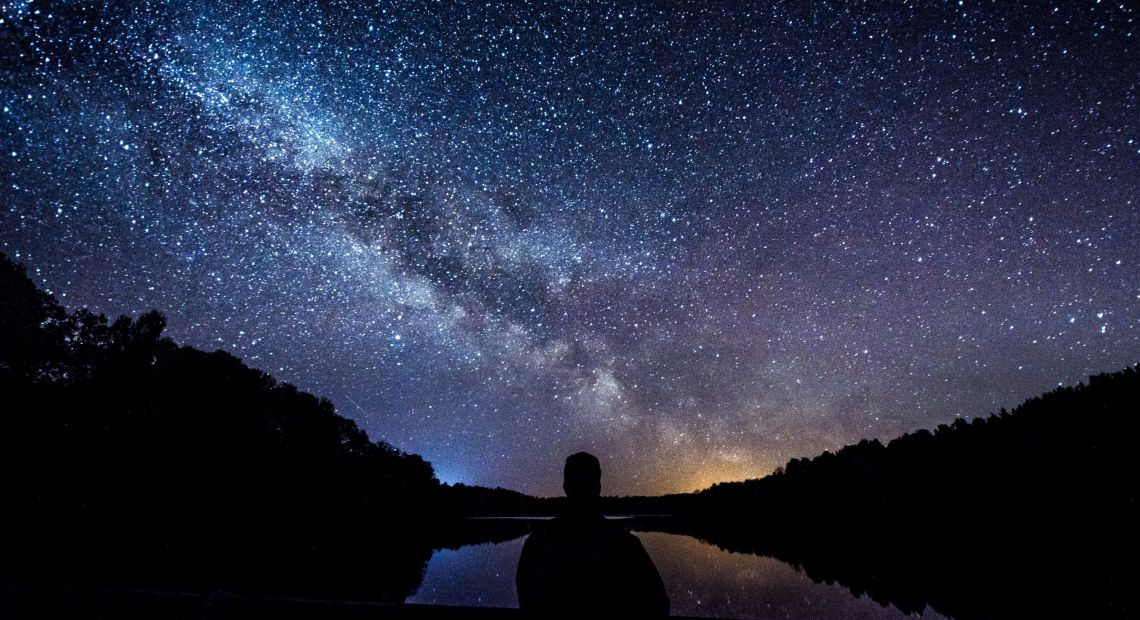 man looking at night starry sky