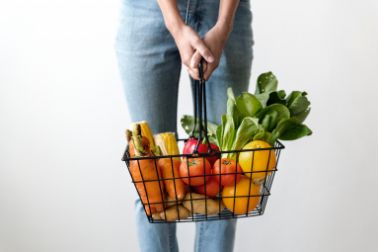 Woman holding a basket with vegetables