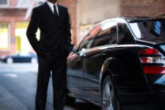 man in black suit near black car