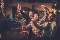 three men drinking beer and having fun in pub