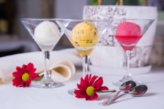 red flowers and three glasses with ice cream on table