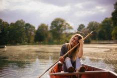 girl in boat with paddles on lake