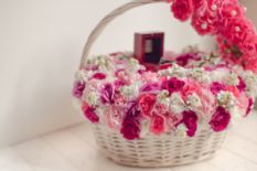 white basket with pink and white flowers and small gift box