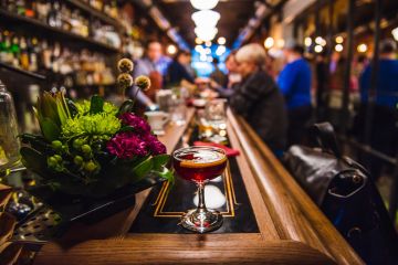 Independence square in Kyivlong bar counter with cocktail and flowers and people on the background