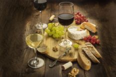 three glasses of wine, bread, cheese, nuts and grapes