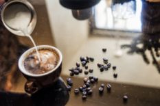 Cup of coffee with milk and coffee beans