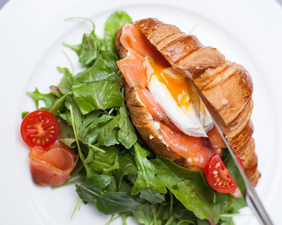 croissant with salmon, salad and egg