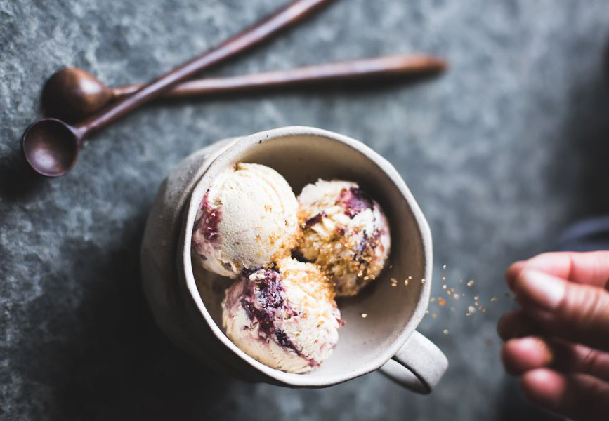 cup with three ice cream scoops and two spoons