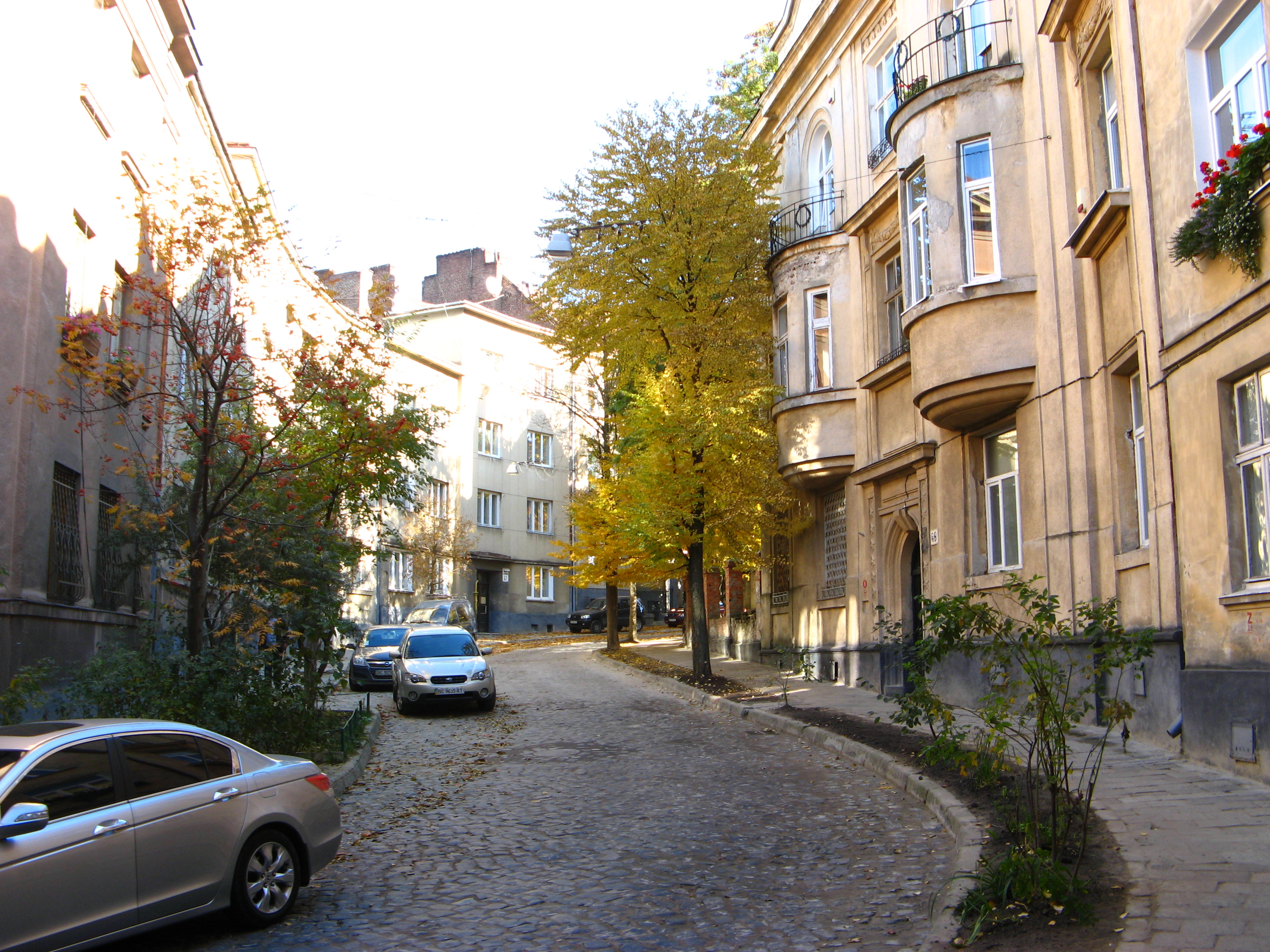 narrow street with buikdings and cars