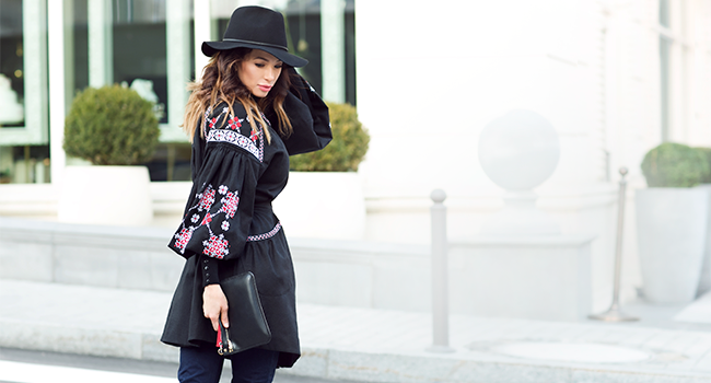 girl in black embroidered shirt and black hat