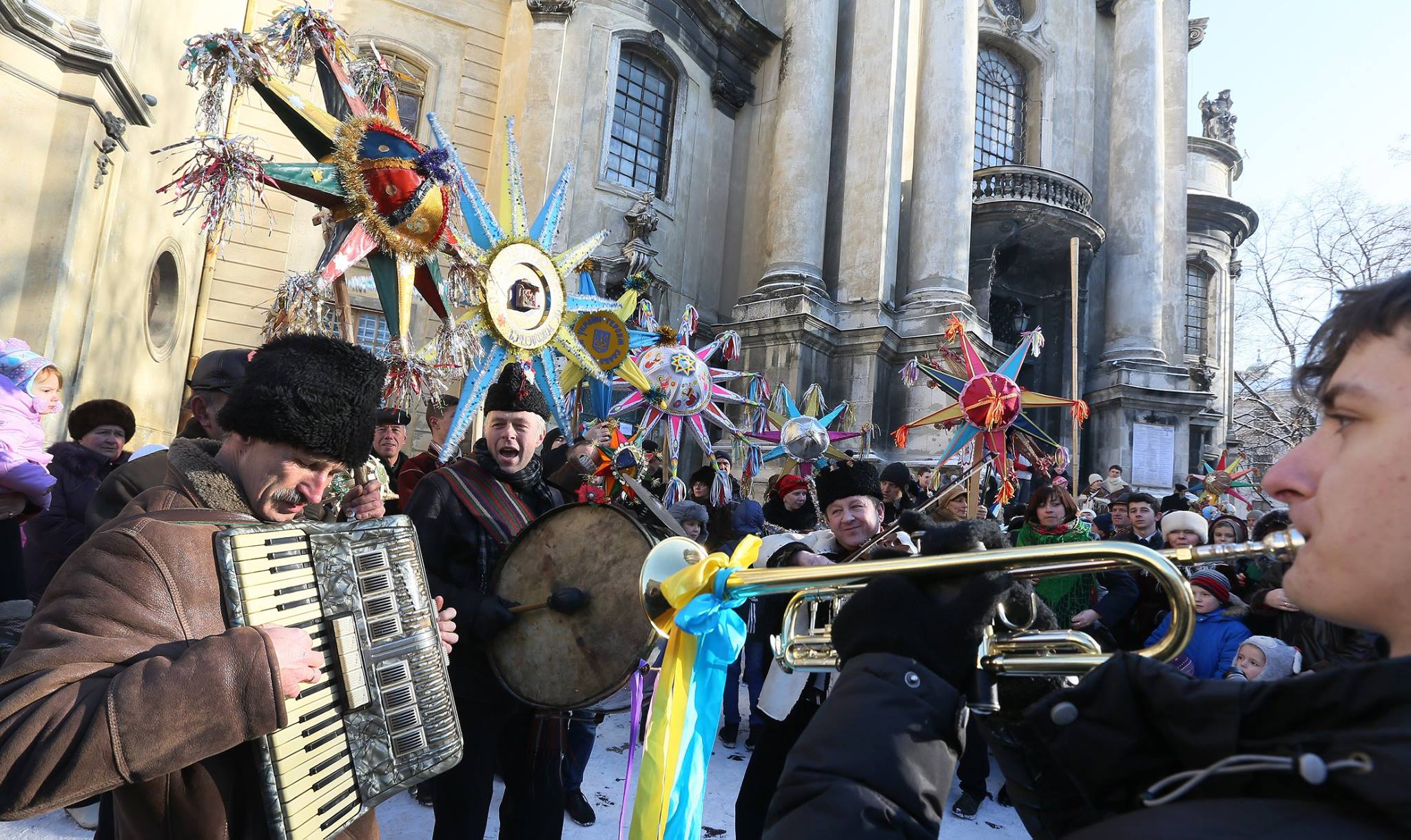 many people with christmas stars on the street playing musical instruments