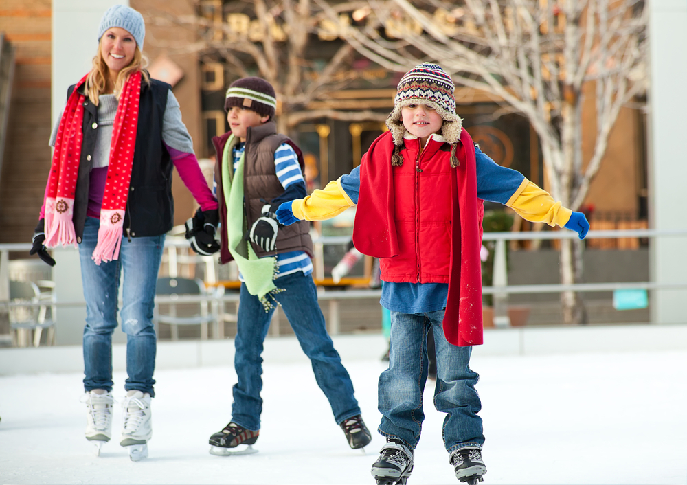 Kids with mother on an ice skating rink