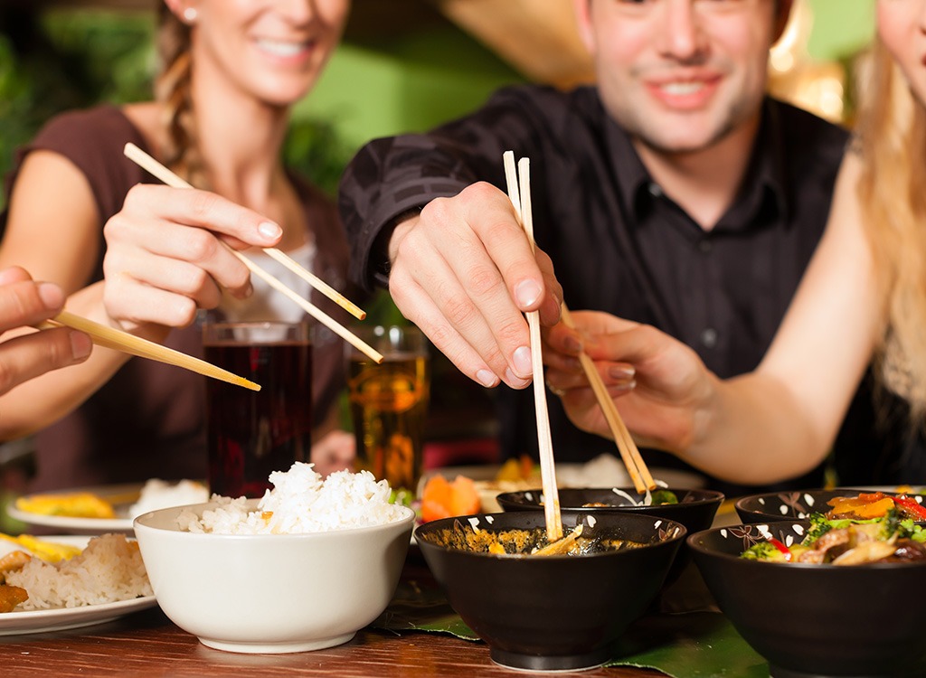 people eating with sticks