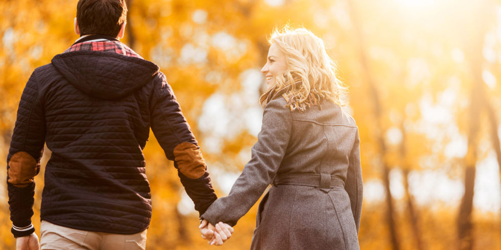 couple holding hands in autumn park