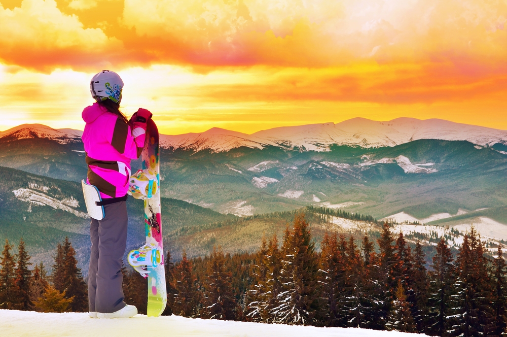 girl snowboarding in mountains