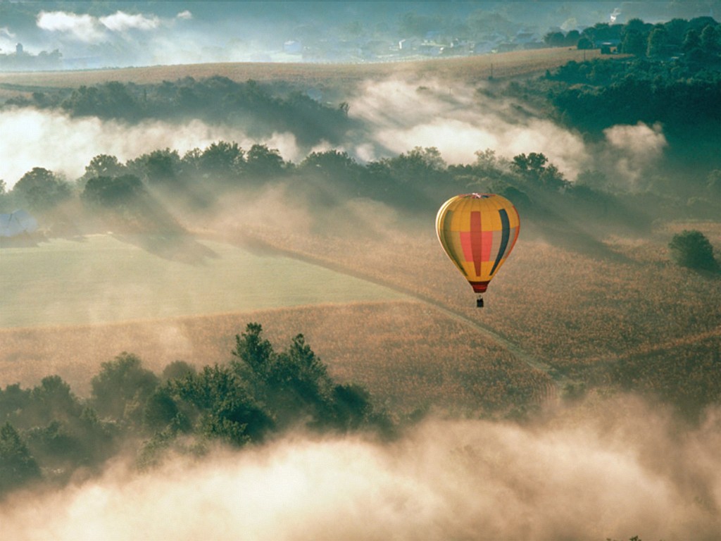 Huge ballon flying over the hills