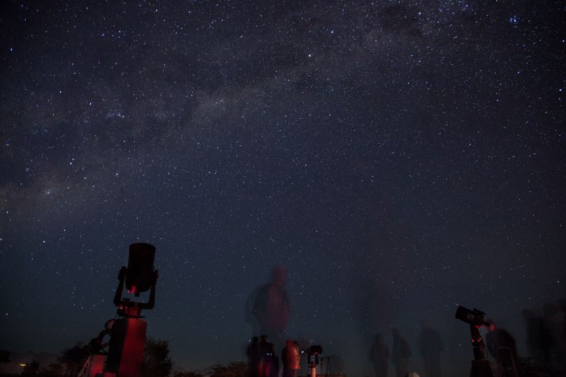 telescopes under night starry sky