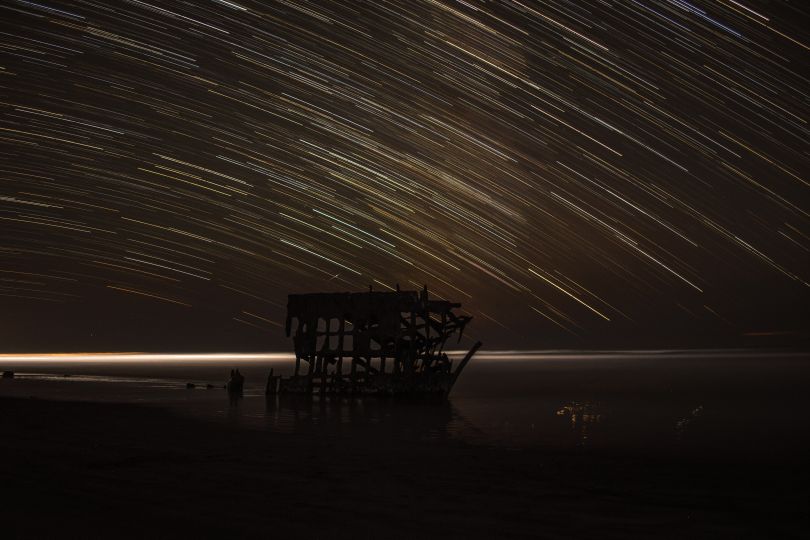 star shower upon structure on water at night