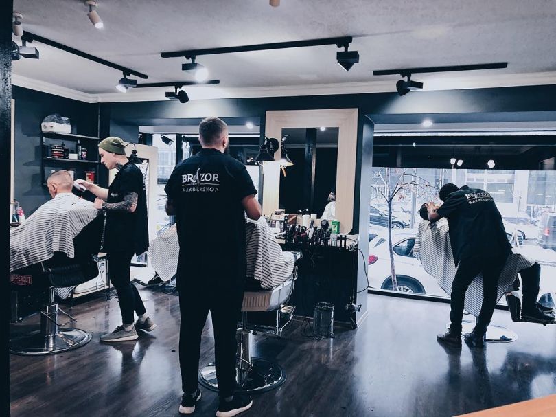 working space of a barbershop woth barbers and clients