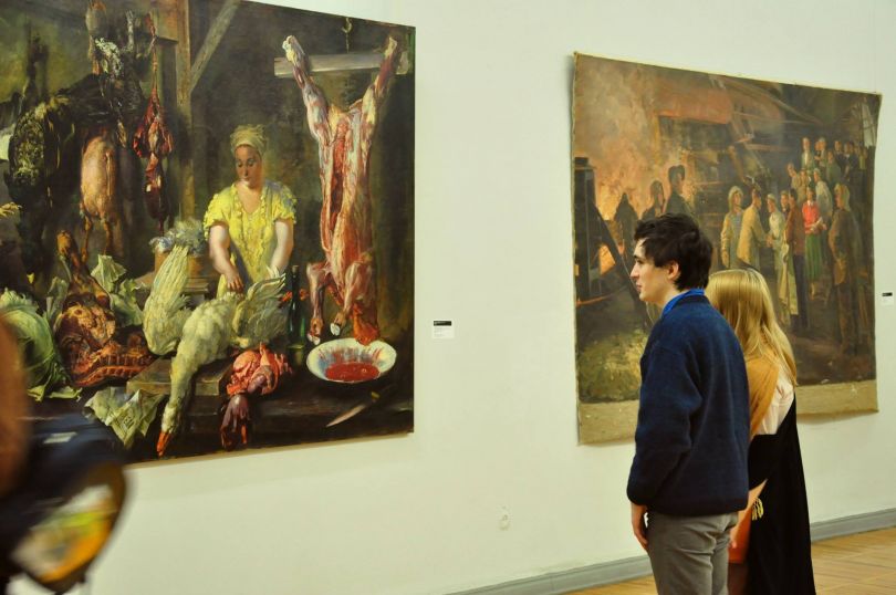 people looking at paintings in gallery