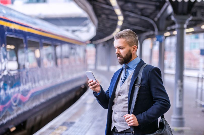 man with smartphone on train station