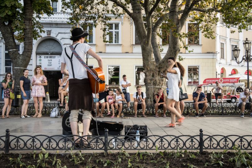 street musiscian playing guitar for people