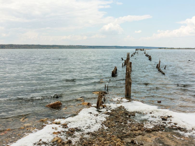 seashore with wooden columns in water