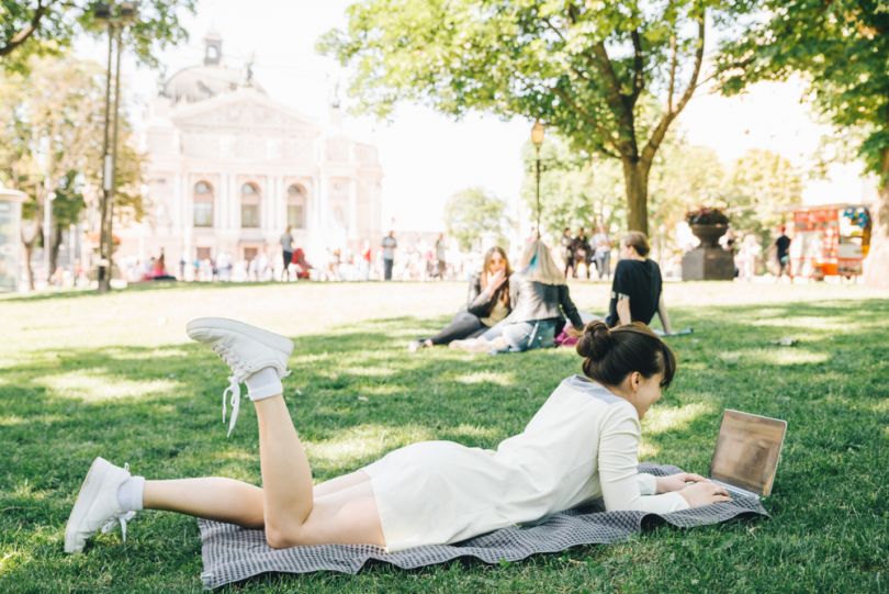 Girl chilling in a park with laptop