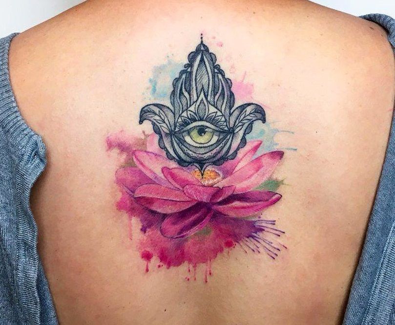 tattoo of flower with eye on female back