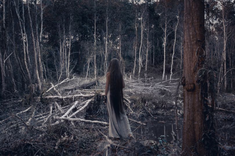 girl with long hair in creepy forest