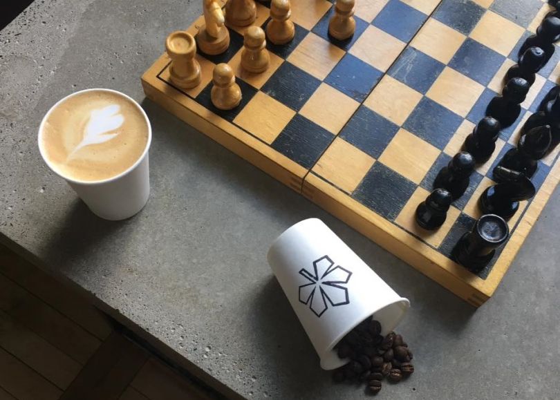 chess, glass with coffee and empty glass on table