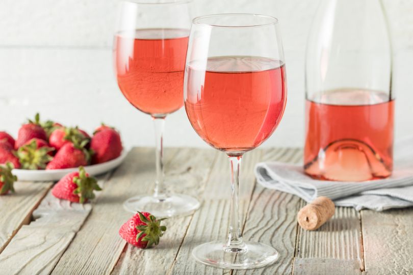 bottle and two glasses with rose wine and strawberries