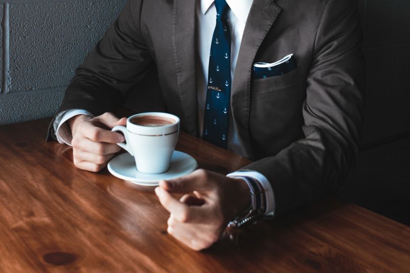 Man in suit drinking coffee