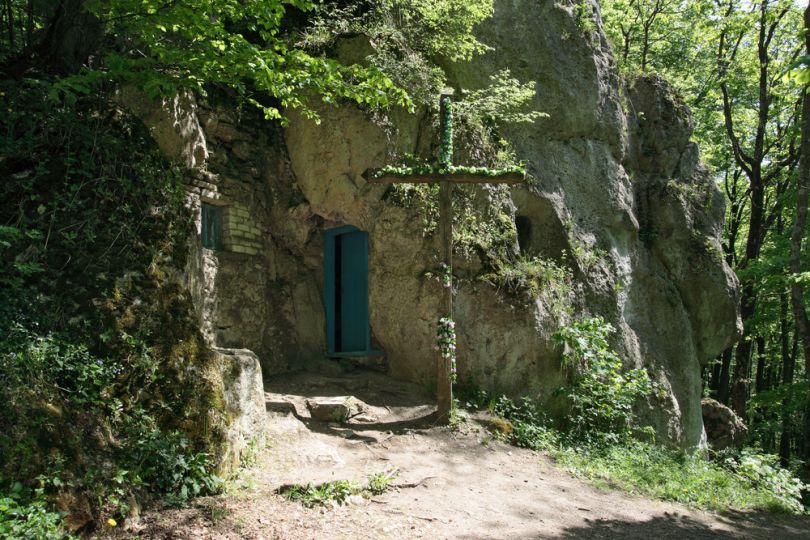 cave in rocks with cross on entrance