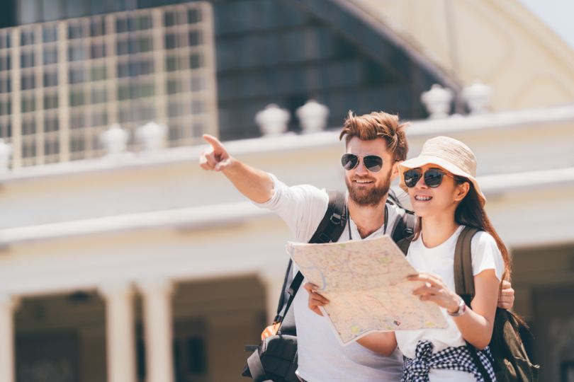 man explaining way to female tourist with map