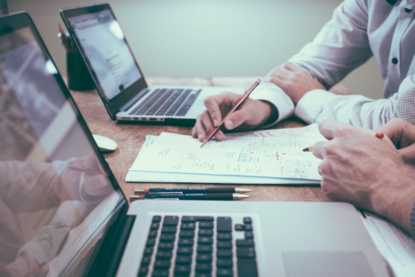 People consulting in front of a laptop