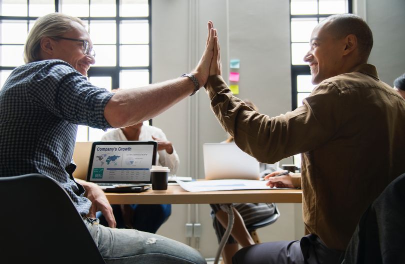 People giving high fives on a business workshop