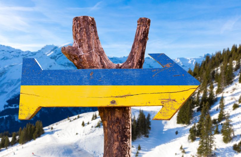 sign with colors of ukrainian flag in snowy mountains